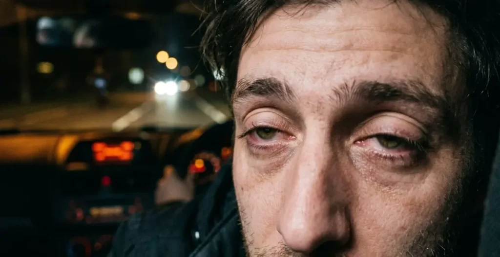 Gros plan sur les yeux d'un conducteur montrant les signes de fatigue avec paupières lourdes